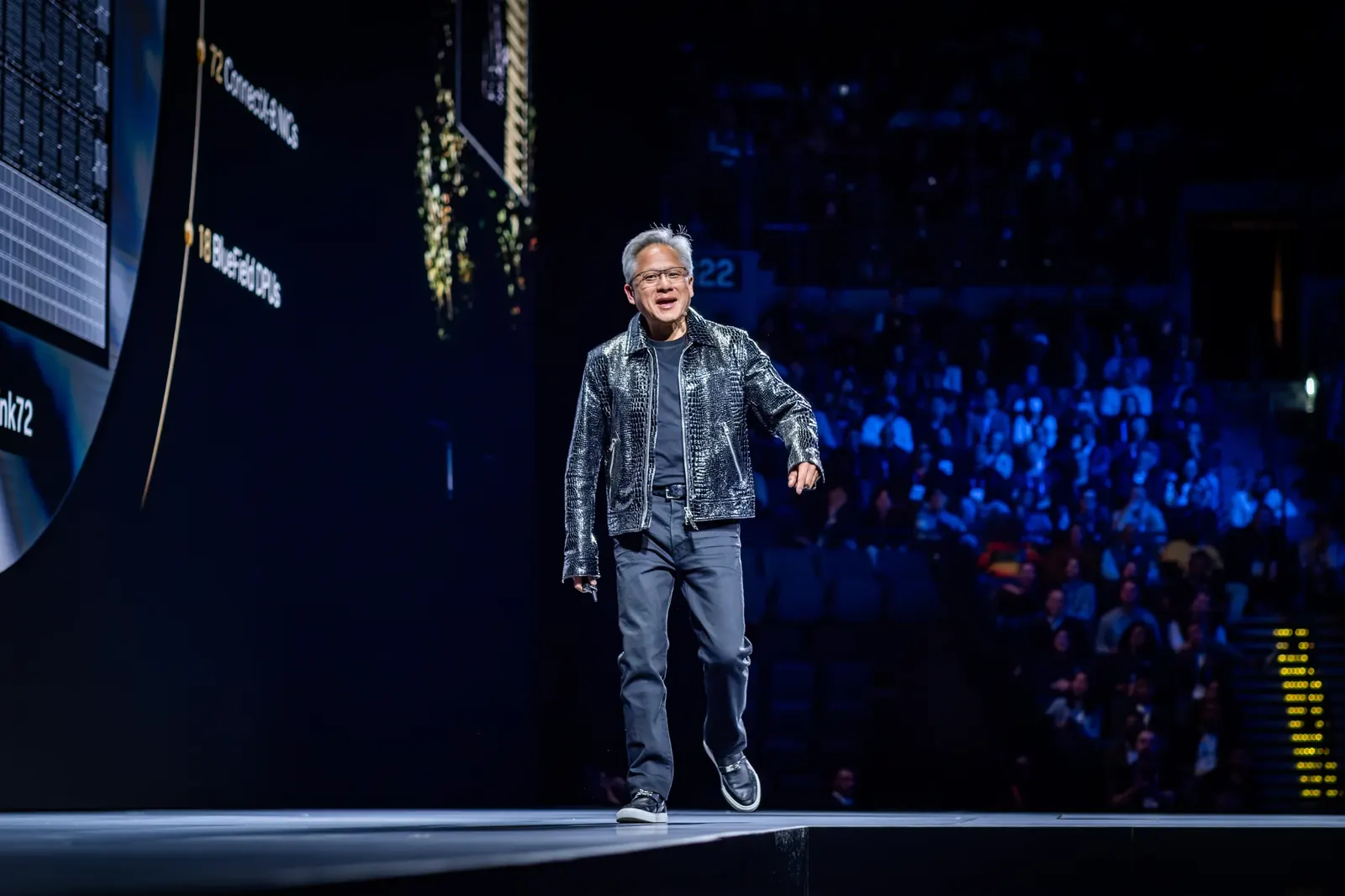 Speaker walking on a conference stage with the audience behind