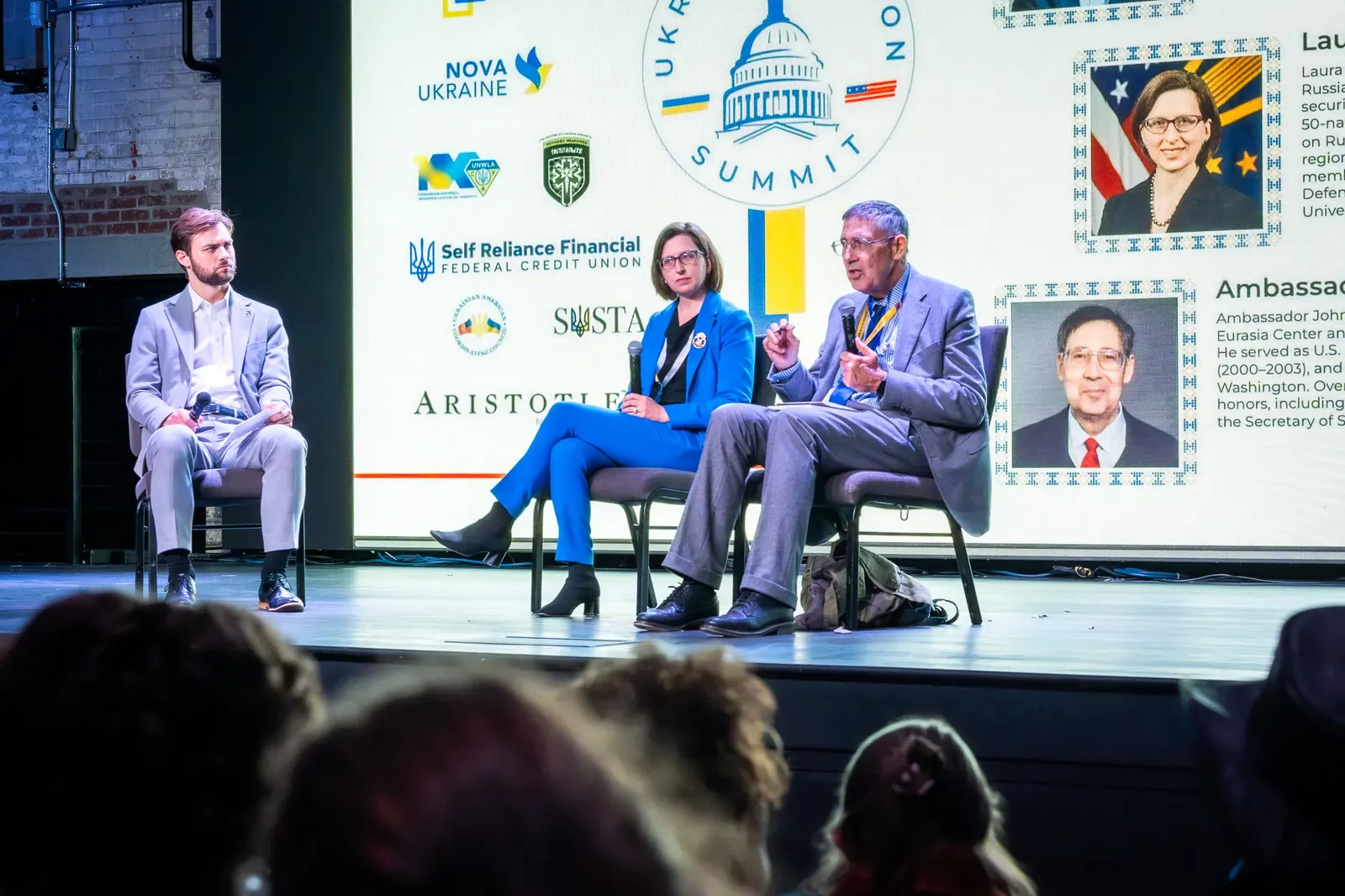 Three participants in a conference panel discussion